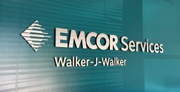 Walker-J-Walker logo on a teal office lobby wall